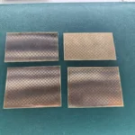 Four rectangular vintage gold-plated PCB substrate plates with etched grid markings
