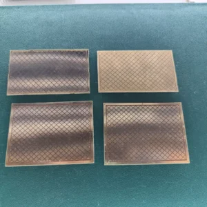 Four rectangular vintage gold-plated PCB substrate plates with etched grid markings