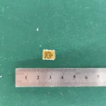HP HCPL-5731 gold-ceramic optocoupler with ruler on green background