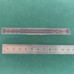 Vintage linear CCD sensor in ceramic package with gold pins and ruler for scale