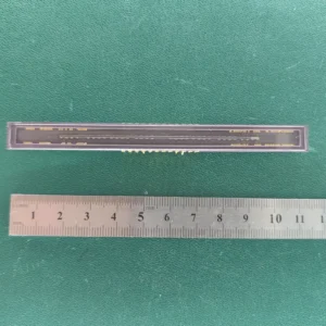 Vintage linear CCD sensor in ceramic package with gold pins and ruler for scale