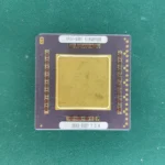 HP 1FE4-0007 ceramic CPU substrate with a large gold top plate on a green background.