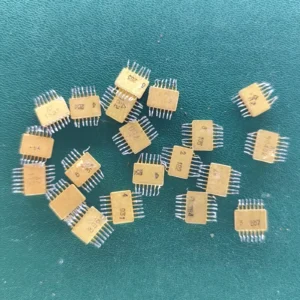 Twenty USSR ceramic ICs with gold pins scattered on a green background.