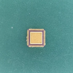 Vintage ceramic IC with gold top and gold pins on green background