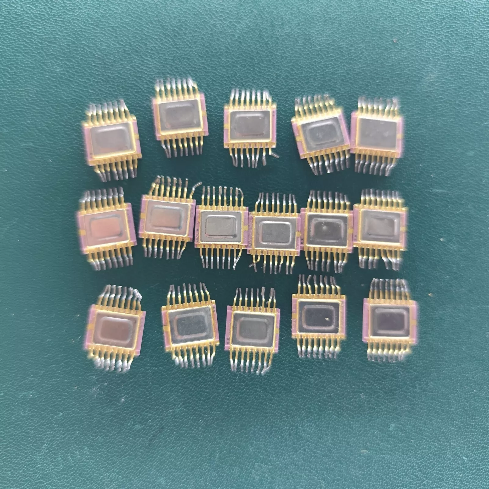 image_5 Lot of 16 USSR ceramic microchips with gold pins arranged on a green background